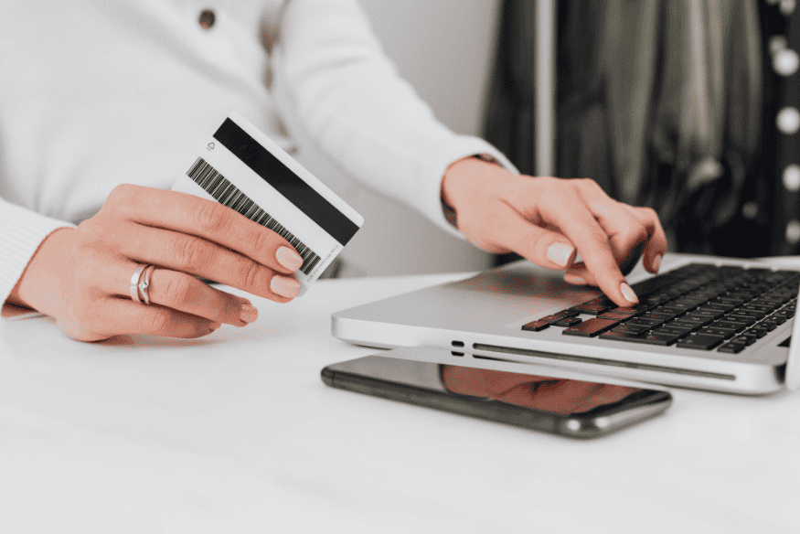 Using a credit card and laptop to manage credit utilization strategies and control credit card balances in the US