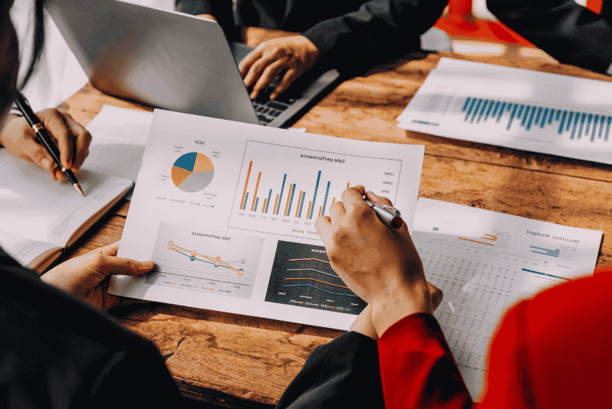 People reviewing financial reports and budget charts together, planning savings and emergency funds in the US