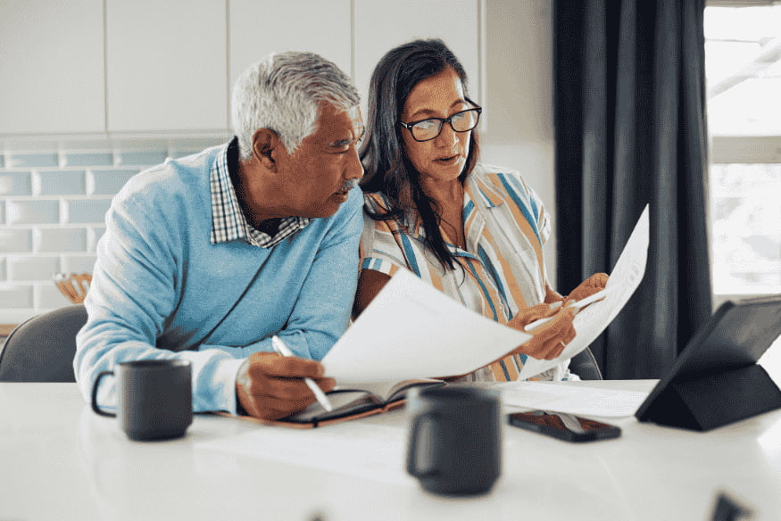 Couple reviewing financial documents together, showing responsible money habits without using credit as a financing tool