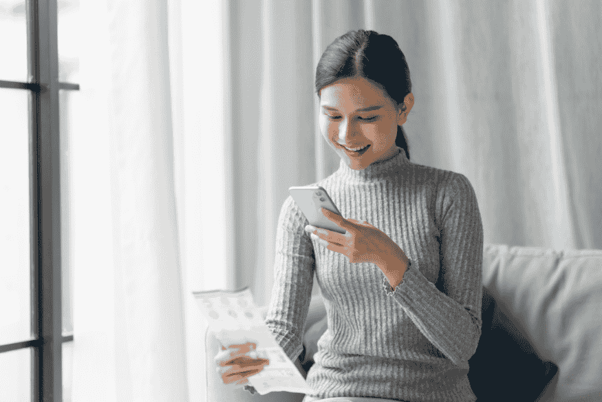 Woman using a smartphone to manage finances, representing the future of online banking in the United States